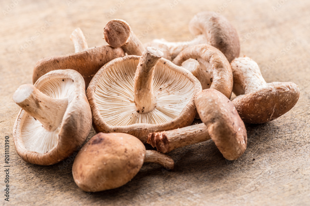 Shiitake mushrooms on the wooden background.