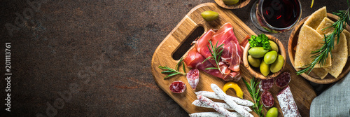 Fotografie Antipasto - sliced meat, ham, salami, olives and wine  top view.