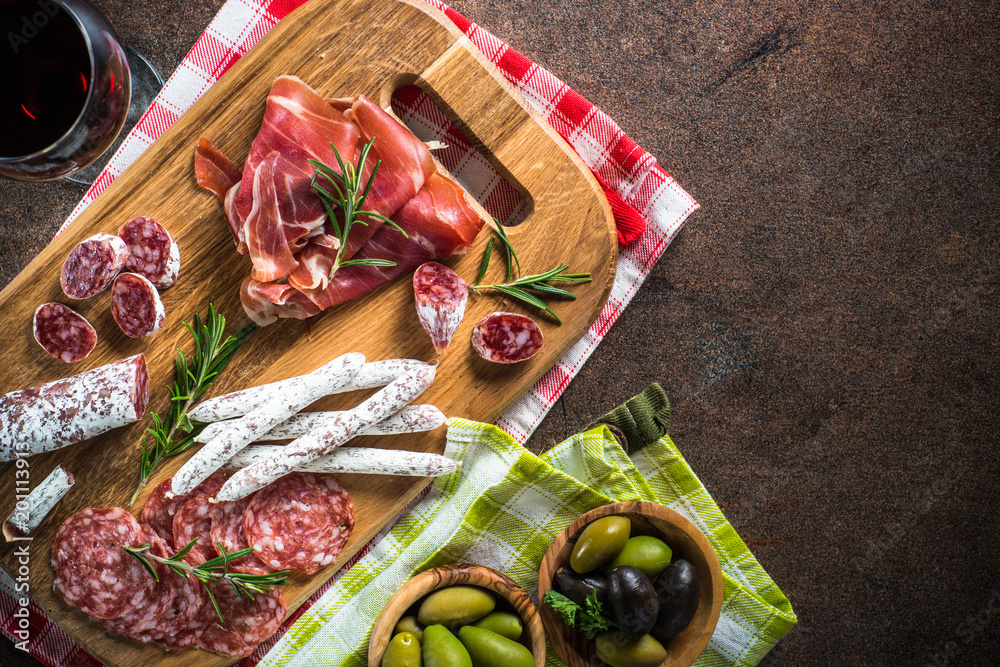 Antipasto - sliced meat, ham, salami, olives and wine  top view.