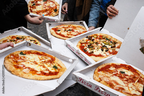 Overhead shot of friends at the street with take-away pizza