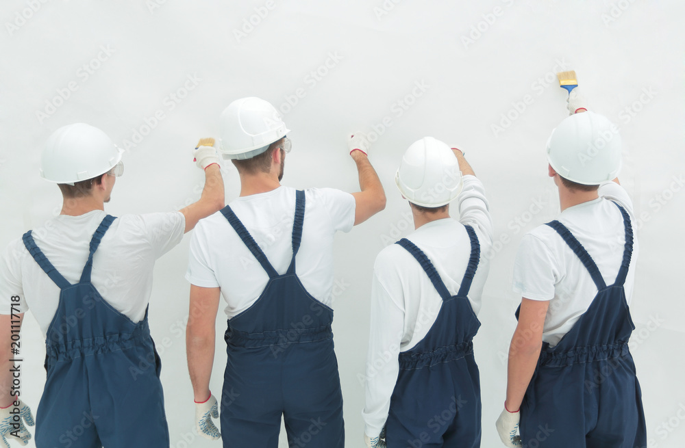 rear view.construction workers paint the wall. rear view.construction workers paint the wall.