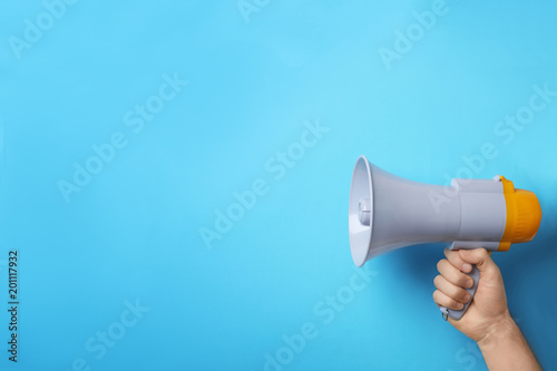 Man holding megaphone on color background