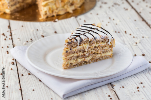 Dark chocolate vegan cake with candies and nuts on wooden background