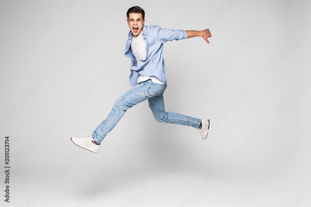 Handsome young man jumping isolated on white background