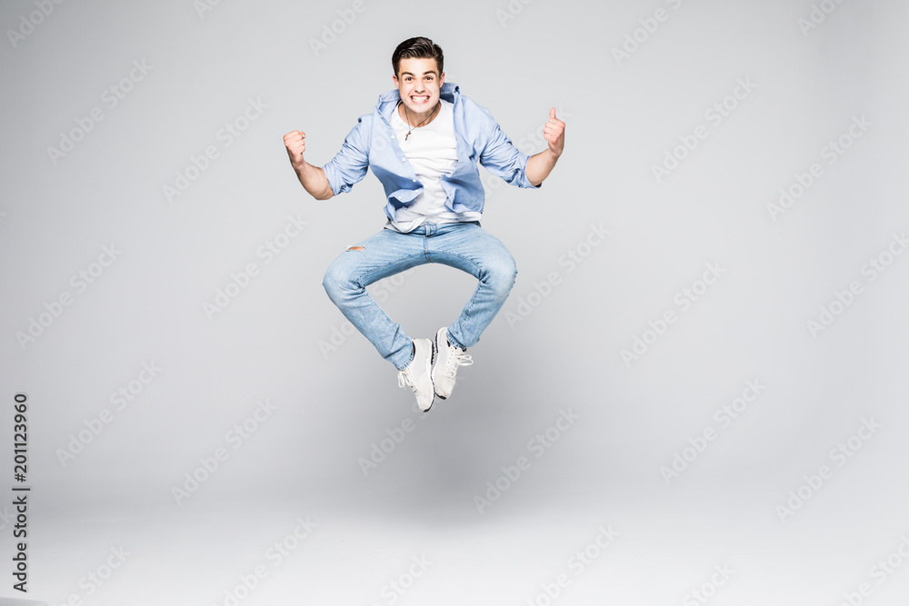 Happy man in shirt and jeans which jumping in studio over white background Happy man in shirt and jeans which jumping in studio over white background