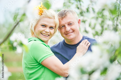 Family. Smiling adult couple in love. Blossoming tree garden