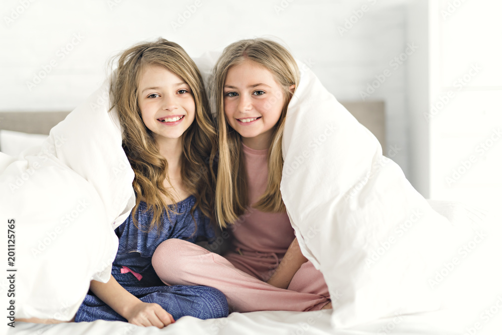 Portrait of two girls child friend in bed wearing pajamas Portrait of two girls child friend in bed wearing pajamas