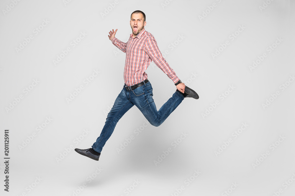 happiness, freedom, movement and people concept - smiling young man jumping in air isolated on white