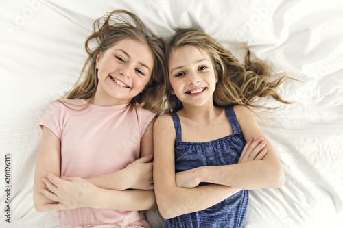 Portrait of two girls child friend in bed wearing pajamas