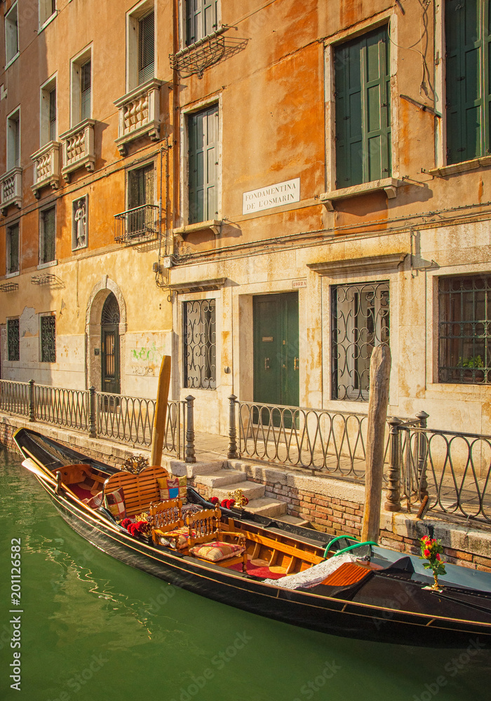 Narrow canal with gondola in Venice, Italy