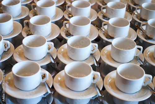 Set of Empty white ceramic tea or coffee cup and saucers  top view. Group of empty cups stacked in rows for serving coffee in restaurant