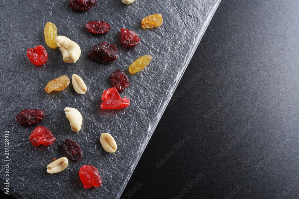 nuts dried fruits on a dark stone background