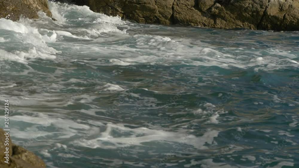 Foamy waves crashing on rocks Foamy waves crashing on rocks