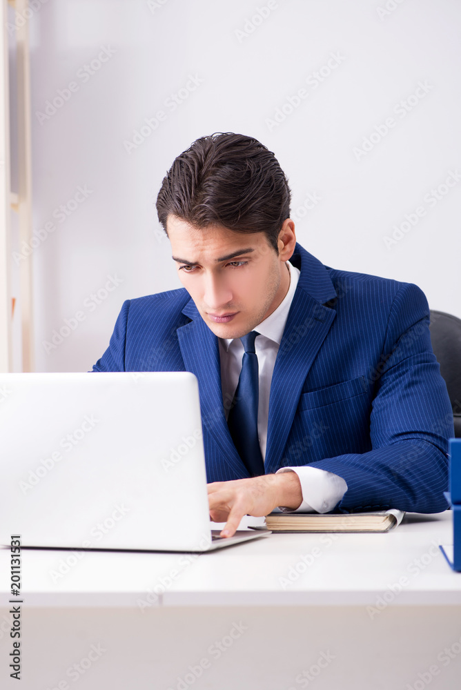 Young handsome businessman employee working in office at desk Young handsome businessman employee working in office at desk