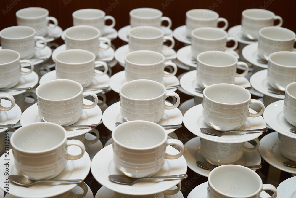 Set of Empty white ceramic tea or coffee cup and saucers, top view. Group of empty cups stacked in rows for serving coffee in restaurant