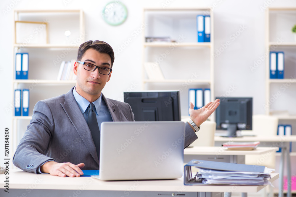 Handsome businessman employee sitting at his desk in office Handsome businessman employee sitting at his desk in office