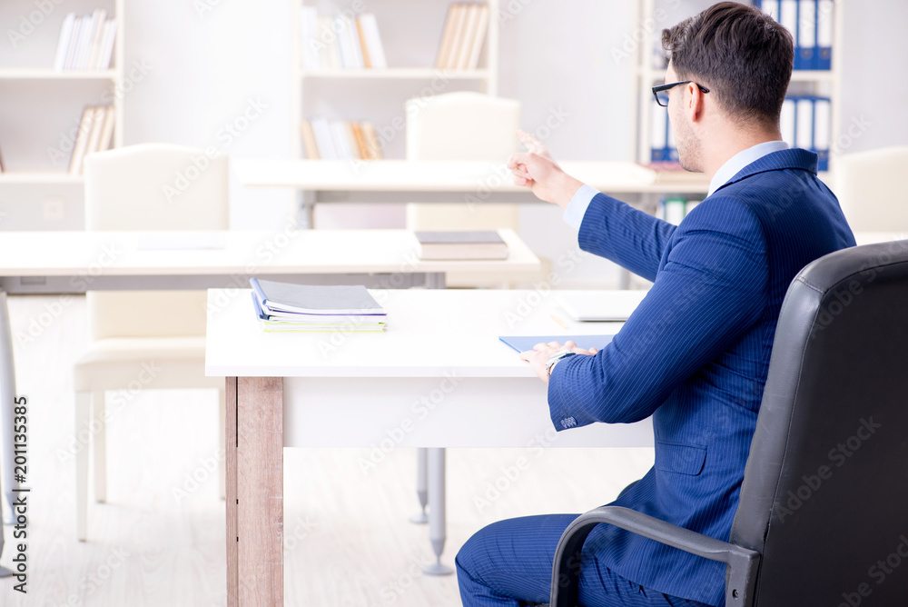 Young handsome businessman employee working in office at desk Young handsome businessman employee working in office at desk
