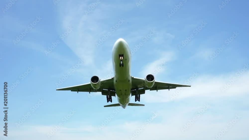 Jet plane approaching landing across blue sky Jet plane approaching landing across blue sky
