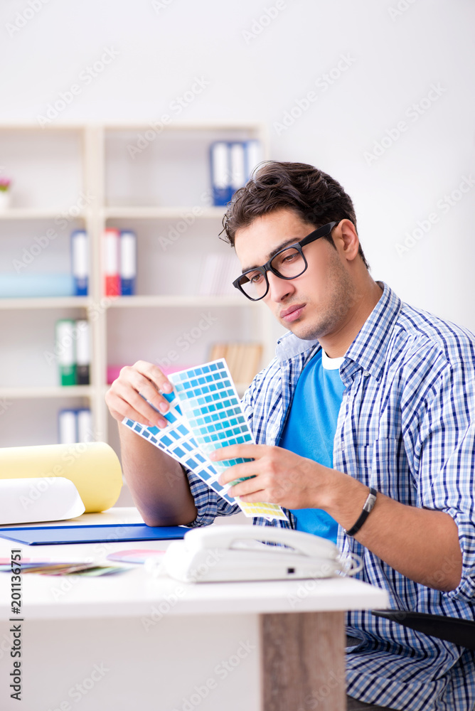 Young designer working on new project and choosing colours Young designer working on new project and choosing colours