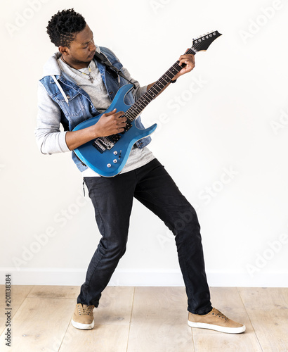 African descent man playing electric guitar