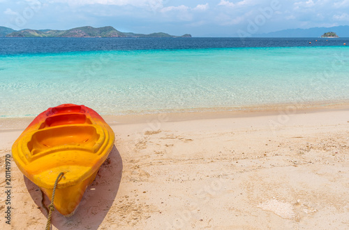 View of kayak on tropical beach on the Banana island, Palawan, Philippines. Beautiful tropical island with sand beach, palm trees. Travel concept