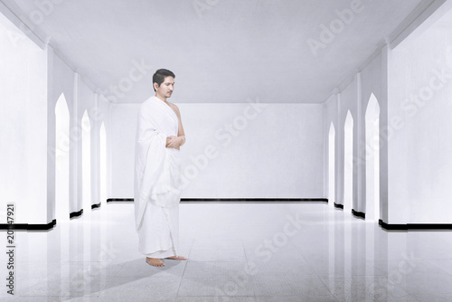 Photo of asian muslim man with ihram cloth praying