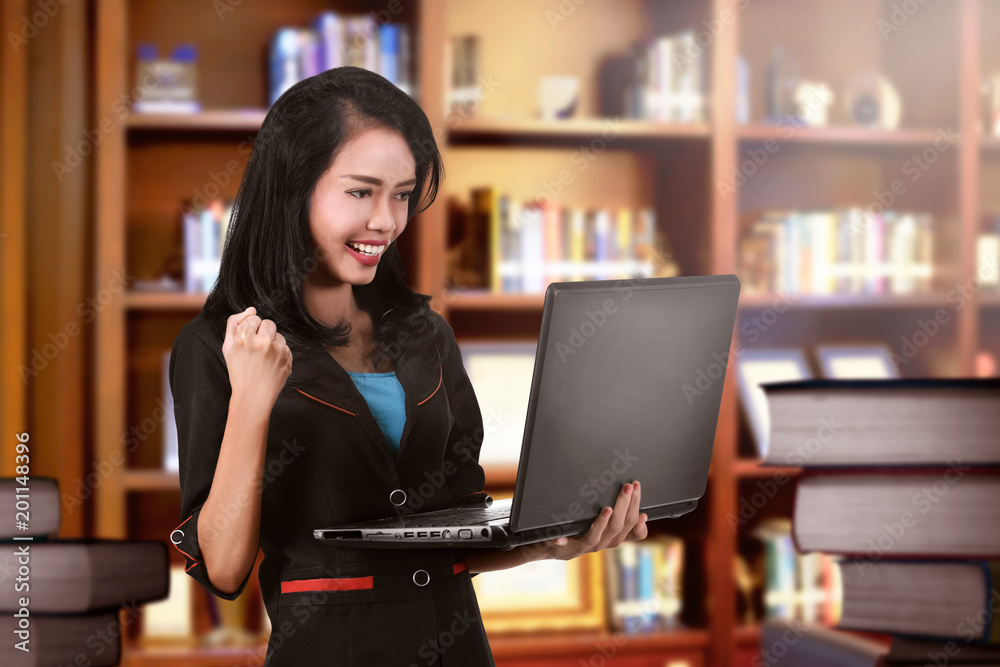 Successful asian business woman standing with laptop Successful asian business woman standing with laptop