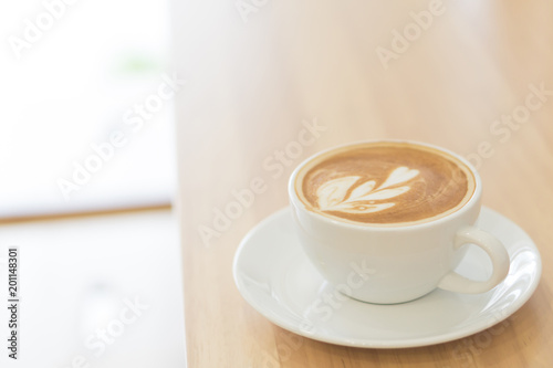 Closeup top view glass of latte art coffee tulip shape on wood background with vintage color, selective focus
