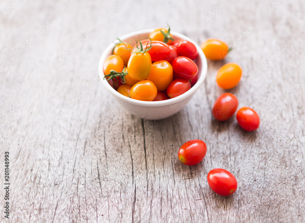 Fresh cherry tomatoes on wood background, raw food and vegetable, selective focus Fresh cherry tomatoes on wood background, raw food and vegetable, selective focus