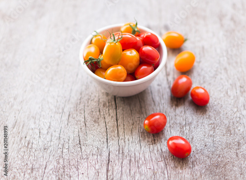 Fresh cherry tomatoes on wood background, raw food and vegetable, selective focus