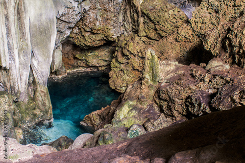 beautiful natural pool of crystal clear water formed in a rocky cave with stalagmites and stalagmites