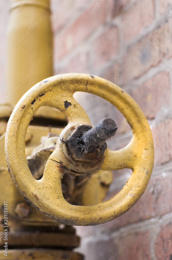 An old rusty gas control valve on the wall.
