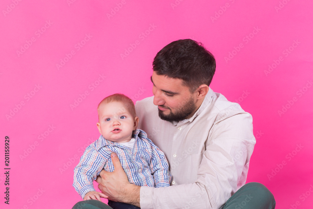 Happy portrait of the father and son on pink background. In studio Happy portrait of the father and son on pink background. In studio