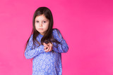 Portrait of a charming brunette little child girl, isolated on pink background