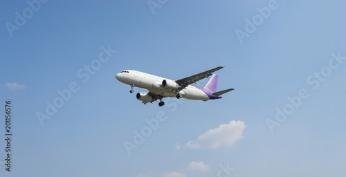 Passenger airplane concept,white airplane is flying in the blue sky with clouds over mountains, sea at colorful. Passengers aircraft is landing,Private jet plane. Travel