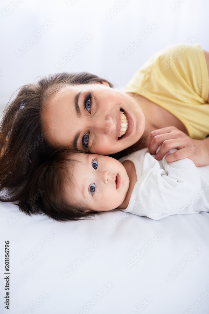 The mother embrace her daughter and  lie on the bed
