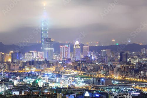 Aerial view of Taipei City with Taipei 101 tower standing tall into clouds  and Keelung River and skyscrapers in downtown area in evening twilight   Scenery of foggy Taipei City with polluted hazy air