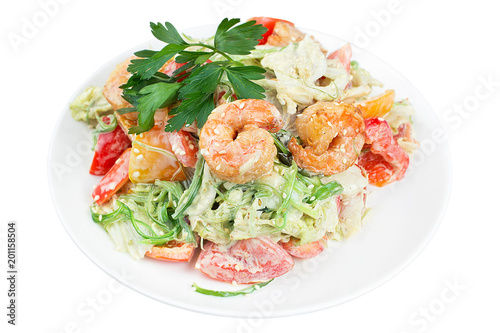 Tasty salad with prawns, vegetables and seaweed Chukka, dressed with sauce on a white plate. Salad in a plate isolated on white background. Seafood salad.