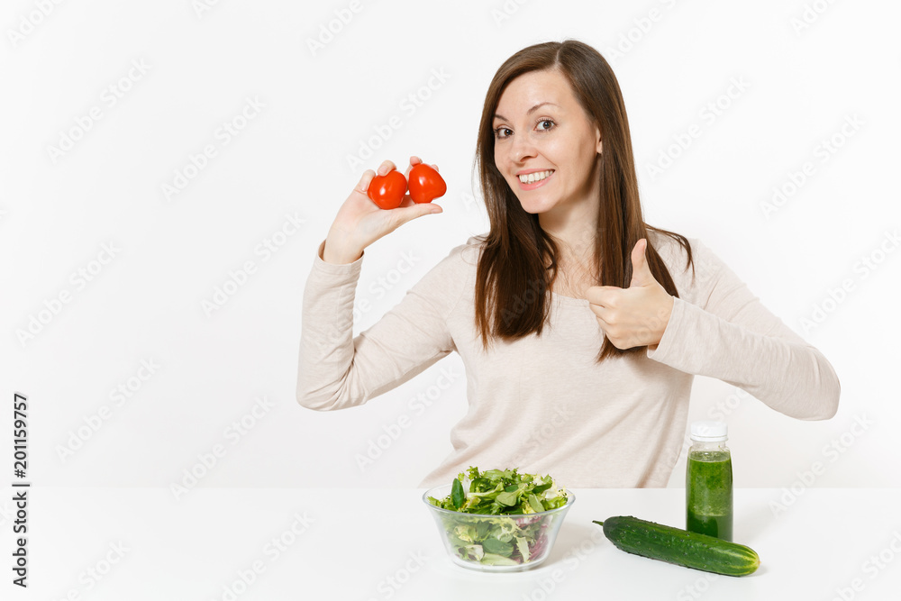 Woman at table with green detox smoothies, fresh salad in glass bowl, tomato, cucumber isolated on white background. Proper nutrition, vegetarian food, healthy lifestyle, dieting concept. Copy space. Woman at table with green detox smoothies, fresh salad in glass bowl, tomato, cucumber isolated on white background. Proper nutrition, vegetarian food, healthy lifestyle, dieting concept. Copy space.
