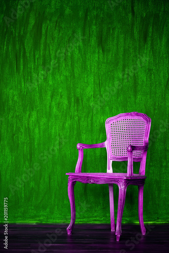 old purple chair on a green wall background. photo