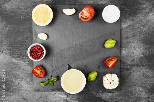 Various spices, herbs and vegetables on dark background. Top view, copy space. Food background