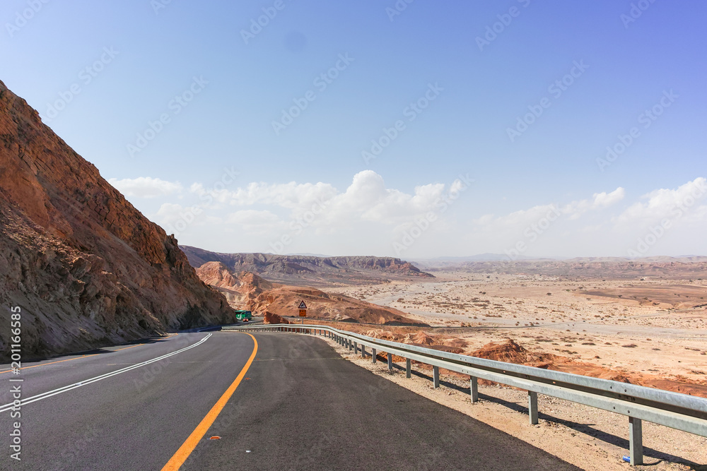 Asphalt road in desert Negev, Israel, road 40, transport infrastructure in desert, scenic mountains route from Eilat to north of Israel Asphalt road in desert Negev, Israel, road 40, transport infrastructure in desert, scenic mountains route from Eilat to north of Israel