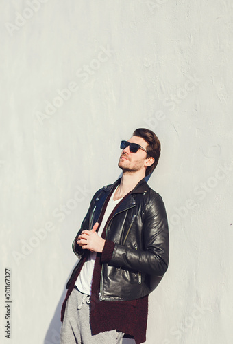 Handsome businessman with sunglasses and leather jacket. Charming and modern style. Cool hairstyle.