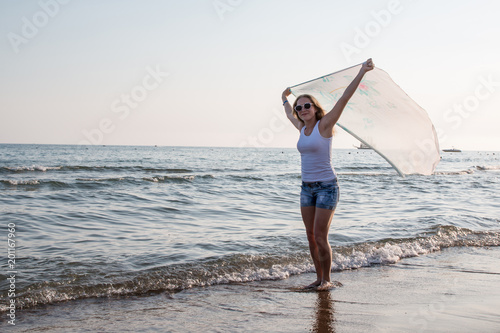 Blond teenager girl on the beach near sea