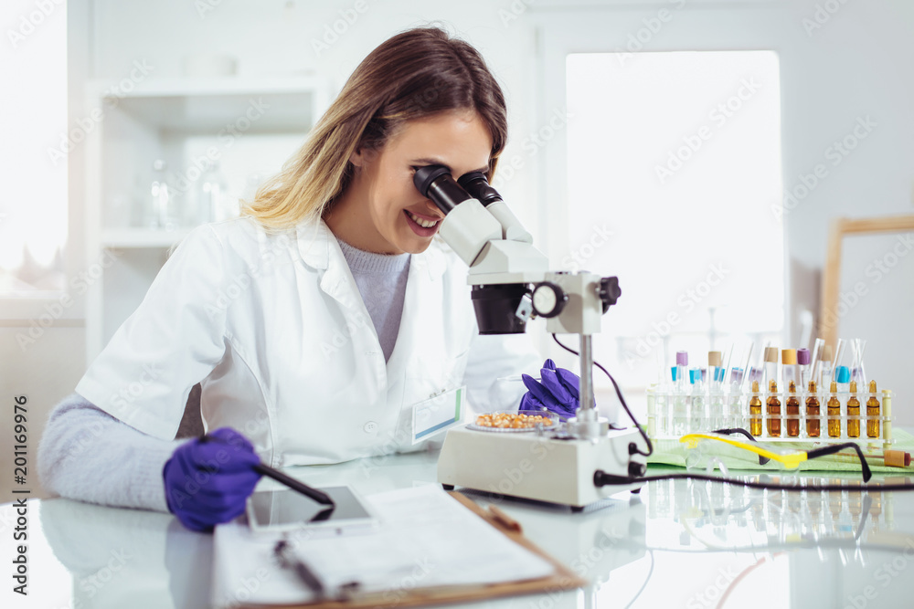 Female scientist looking corn for genetic modification research in laboratory Female scientist looking corn for genetic modification research in laboratory