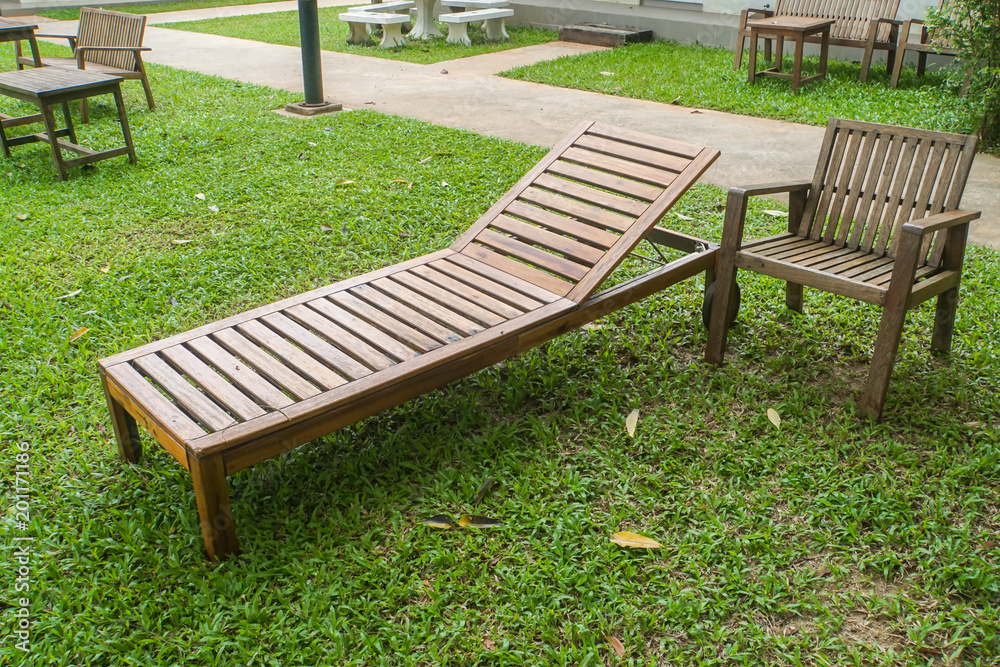 wooden bed and armchair at green lawn in front of the house for rest wooden bed and armchair at green lawn in front of the house for rest