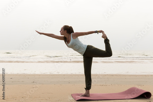 Junge sportliche Frau am Strand mit verschiedenen Posen, Yoga, Konzept