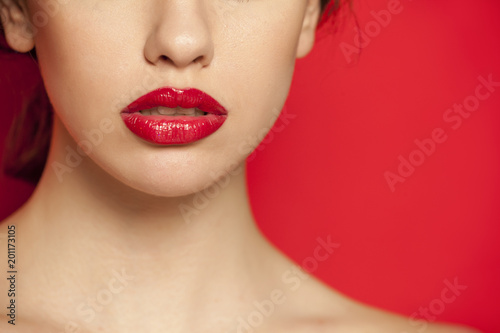 red glossy lipstick on red background