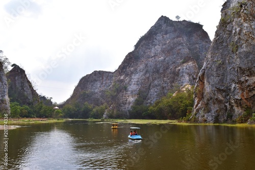 Green marsh and two water bikes with gray rocky mountain peaks in background at Khao Ngoo Rock Park,Ratchabur,Thailand   © anant_kaset