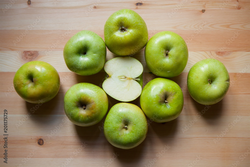 Many green large apples and cut slices Many green large apples and cut slices